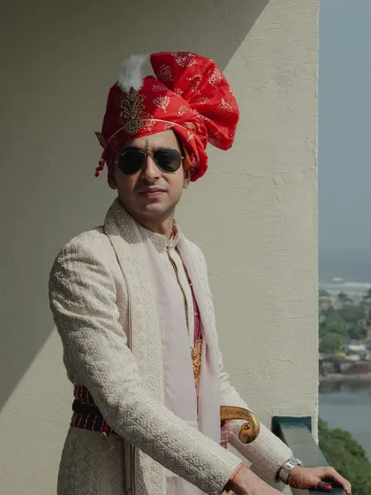 A groom should look and feel just as special on his wedding day. For this look, we chose a classic ivory sherwani with intricate embroidery and paired it with a traditional safa. This portrait captures the quiet confidence and elegance of his final wedding day style.