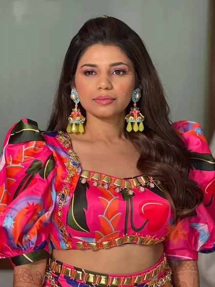 A close-up of the carnival look, showing the simple half-up style that allows the colorful outfit and statement earrings to shine.