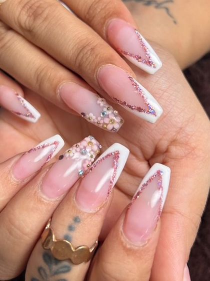 Another look at these custom wedding nails. This design features a deep V-shaped French tip with a line of pink glitter, plus a stunning accent nail with 3D flowers and gems.