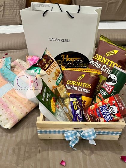 A simple and delicious confectionery hamper, perfect for a birthday surprise. This pinewood crate is filled with a variety of chips from Cornitos and Pringles, along with chocolates and other snacks.