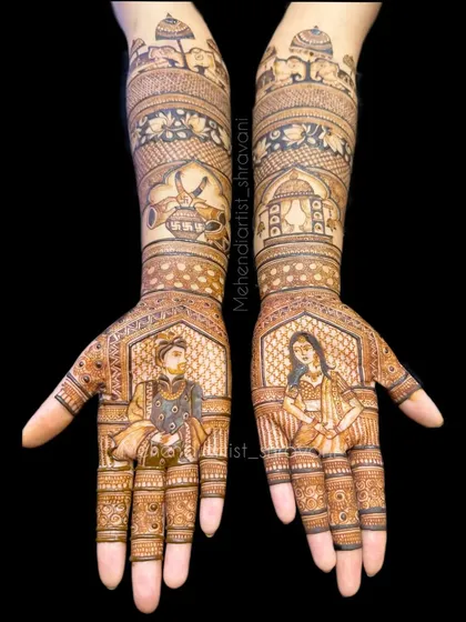 A clear, symmetrical view of a full bridal design. The portraits are the centerpiece, supported by traditional patterns and auspicious symbols on the forearms.