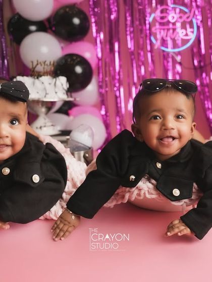 Twin girls celebrating their half-birthday in style. Dressed in matching black outfits, they are double the cuteness.