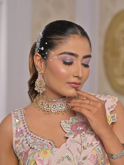 A close-up of the makeup and jewellery paired with the heart-patterned lehenga, showing a complete festive look.