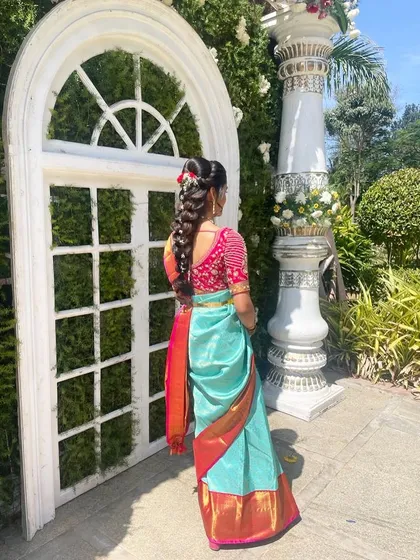 A view of the intricate traditional hairstyle, a key part of the overall look. The makeup on her face is balanced to work with the elaborate hair and outfit.
