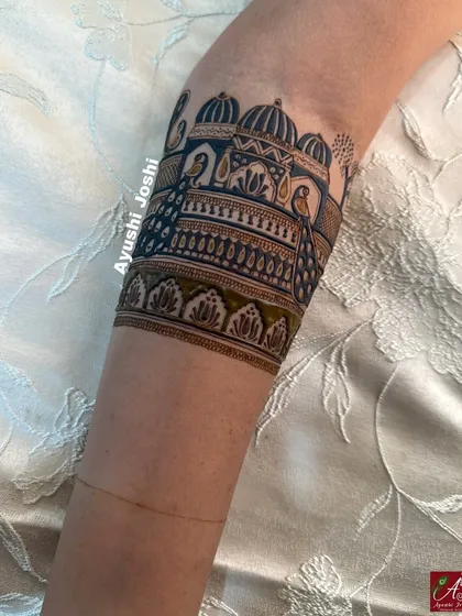 A close-up of a bridal armband featuring a royal palace and peacocks, with beautiful shading that creates depth.