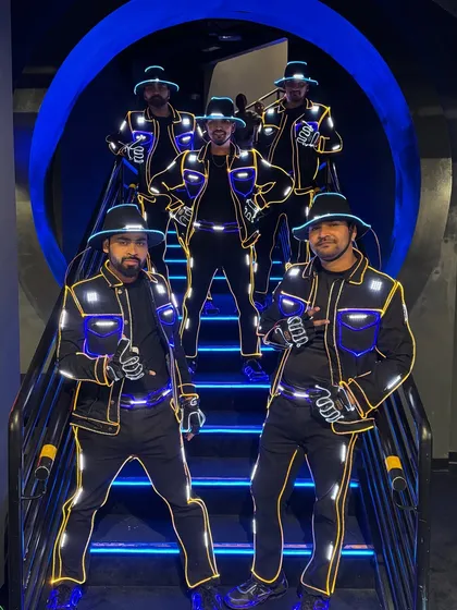 The crew on a futuristic, blue-lit staircase at Doha Festival City. We always find the best spots for a quick photo shoot between performances.