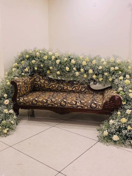 Another view of the at-home engagement sofa decoration. The full arch of baby's breath and white roses creates a beautiful frame for the couple.