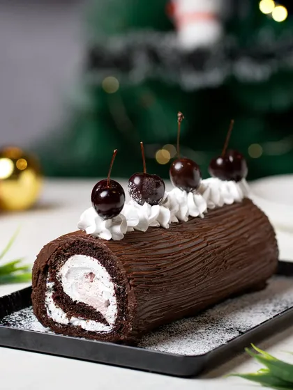 A festive Yule log cake, or Bûche de Noël, styled with cherries against a Christmas-themed background. We specialize in creating visuals for seasonal and festive bakery collections.