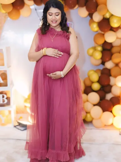 A full-length view of our wine-colored ruffled gown, showing how its gentle layers create a flattering A-line silhouette perfect for a baby shower.