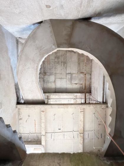 A glimpse of a magnificent spiral staircase during the construction phase. This image showcases the raw concrete formwork, revealing the complex structural engineering that forms the foundation of our most innovative and sculptural designs.