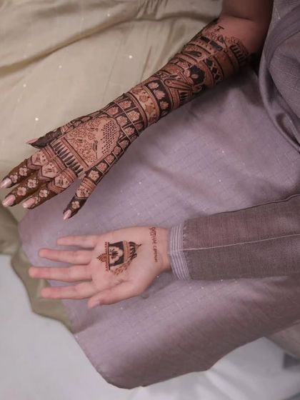 A shot showing the bride's intricate mehandi alongside the groom's simpler design. We cater to both with the same level of care and quality.