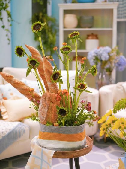 A close-up of the artistic centerpiece, blending edible elements like bread with fresh sunflowers.