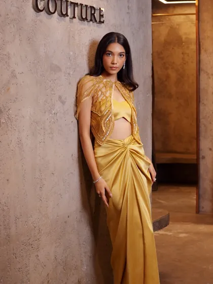 A mustard-hued vision featuring a draped skirt, intricately embroidered blouse, and a cutwork cape that adds just the right touch of drama.