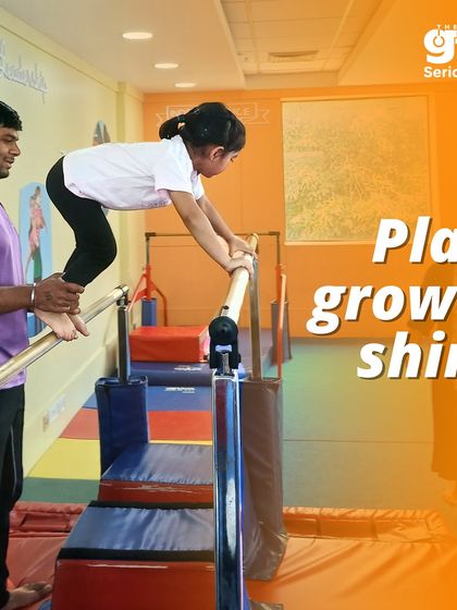 Play, grow, and shine. A coach assists a young girl on the parallel bars, helping her build the strength and confidence to support her own body weight.