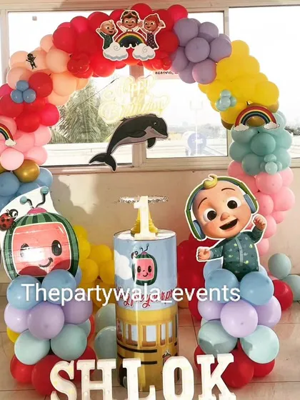 A Cocomelon theme with a fun cable car prop. The rainbow balloon arch and character cutouts make it a very playful and interactive setup.