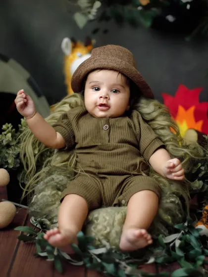 A little explorer on a jungle adventure. Themed milestone sessions like this safari setup are a wonderful way to showcase your baby's budding personality.