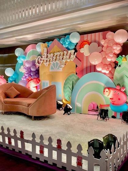 A side view of the Peppa Pig stage, showing the white picket fence border and the arrangement of character cutouts and props.