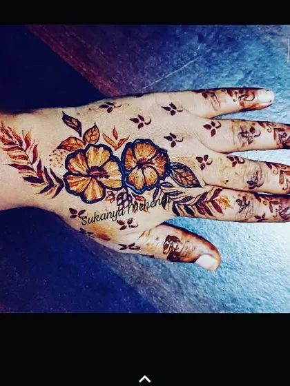 A Dubai-style floral design. This pattern uses shading and bold outlines to create a realistic, tattoo-like effect with henna.