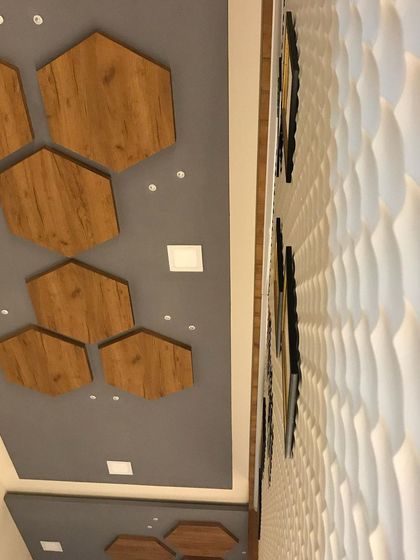 This upward shot shows the contrast between the geometric ceiling panels and the wavy texture of the 3D wall.