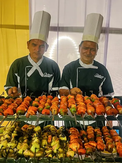 My chefs are ready to serve freshly grilled delights from the live barbeque counter. Here they are presenting a colourful array of perfectly marinated and charred paneer tikka skewers, a guaranteed hit at any celebration.