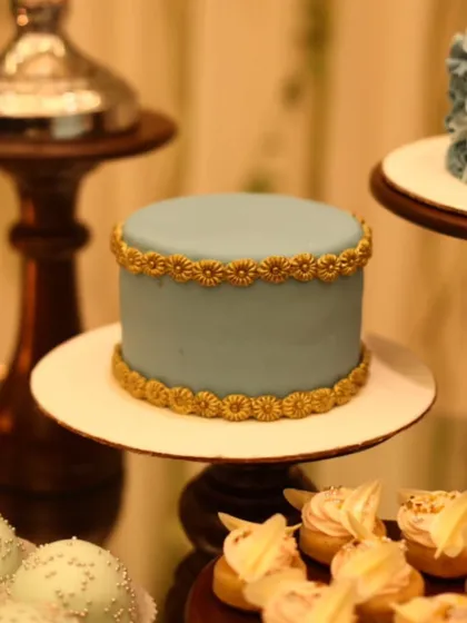 An elegant, minimalist cake with a smooth pastel blue finish and intricate golden border. This is an example of our artisan cakes, perfect for sophisticated celebrations.