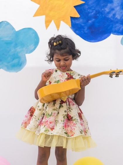 A playful moment in a yellow floral dress. The simple silhouette is elevated by the bright, cheerful print and a tulle trim for extra fun.