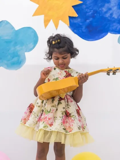 A playful moment in a yellow floral dress. The simple silhouette is elevated by the bright, cheerful print and a tulle trim for extra fun.