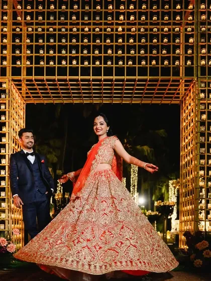 The bride twirls in front of the magnificent candle wall structure. This wide shot shows the scale of the installation and its powerful impact on the overall reception design.