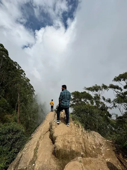 Two friends at the edge of Dolphin's Nose in Kodaikanal.