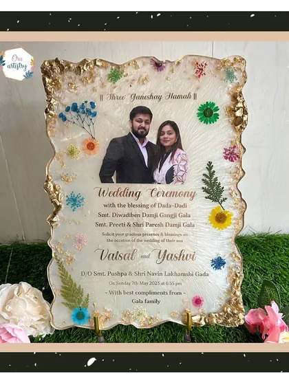 A beautiful resin wedding invitation, decorated with preserved flowers and a gold geode border.