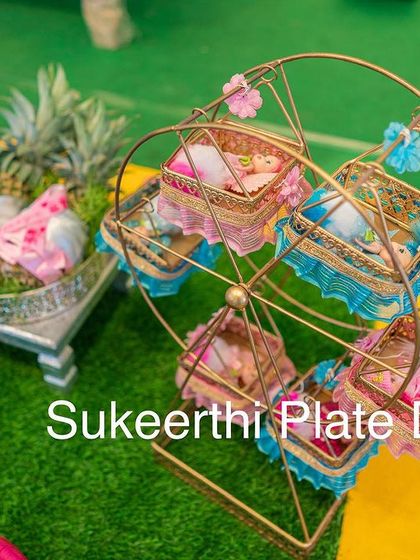 A close-up of the decorative Ferris wheel prop used in a baby shower setup. It's a unique way to display small gifts or sweets.