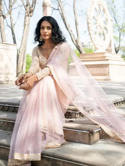 Like a gentle breeze, this pale peach pre-stitched saree is refreshing and elegant. The lightweight fabric flutters beautifully.
