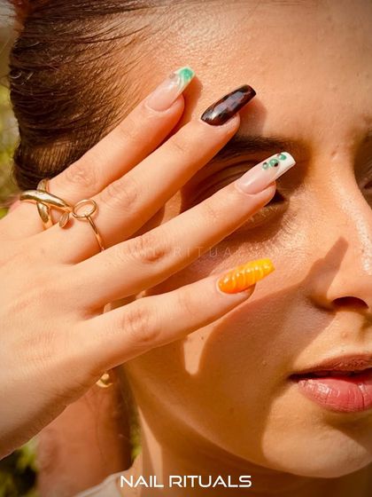 Sun-kissed days and freshly painted tips. This photo captures the essence of summer with a colorful, artistic manicure.