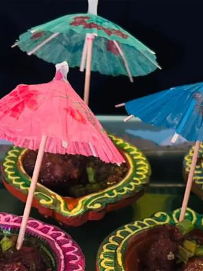 Another angle of the festive Dry Manchurian in diyas. The colorful umbrellas add a playful and celebratory touch to the appetizer station.