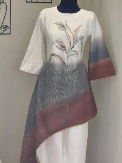I love the hand-painted look of this asymmetrical tunic and pant set. The ombre effect from white to grey and brown, combined with the delicate botanical print, makes this a truly unique fusion piece.