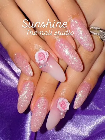 A dreamy pink set featuring full glitter nails and accent nails with 3D roses. This is a perfect example of a glamorous, feminine design that's popular for special occasions.