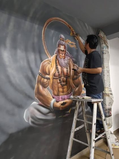 Here I am on a stepladder, working on a detailed graffiti mural of Hanuman ji in a meditative but powerful pose. This piece is designed to bring a sense of focus and inner strength to the gym.