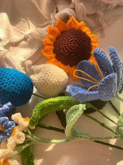 A top-down view of the "golden glow" flower collection, featuring a sunflower, tulips, and other blue and white flowers.