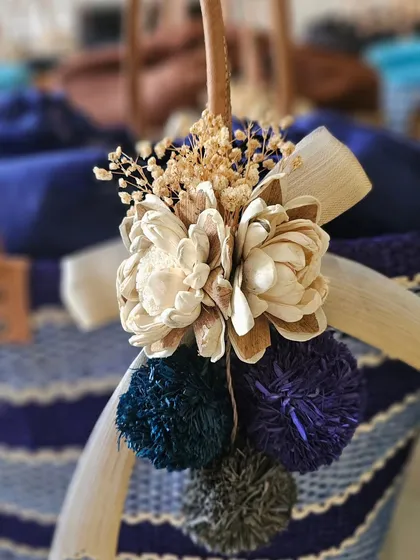 I believe beauty is in the details. This is a close-up of one of my eco-friendly raffia baskets, showing the hand-carved wooden flowers, delicate dried fillers, and colorful pom-poms. It’s these small, thoughtful touches that make a simple gift feel truly special.