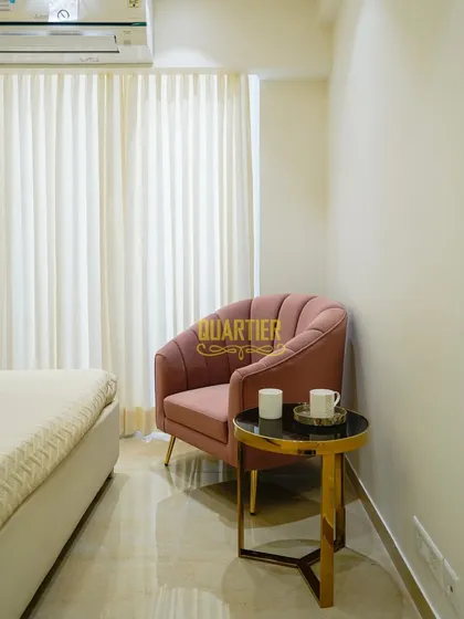 Every corner is an opportunity for design. In this bedroom, I created a cozy reading nook with a plush pink armchair and a small side table, providing a perfect spot to unwind with a cup of coffee and a book.