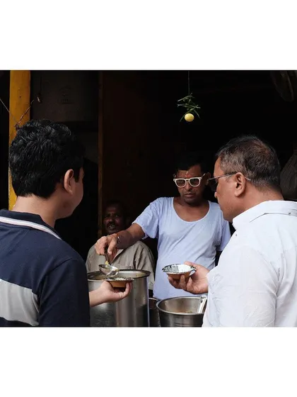 A street food vendor in Chandni Chowk serves customers, a daily scene from the heart of Old Delhi.