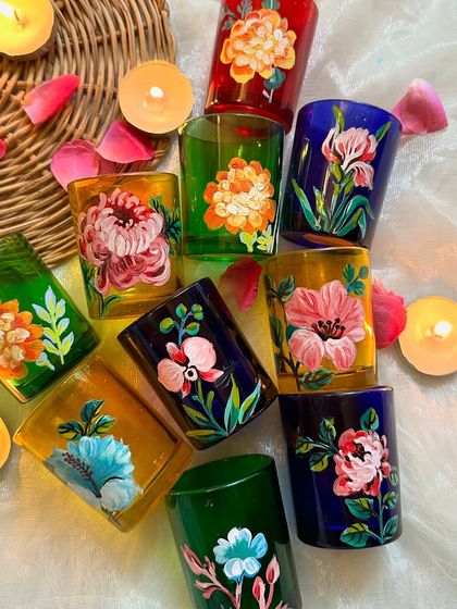 A top down view of our beautiful, hand painted floral candle holders, surrounded by tea lights and flower petals. They are available exclusively on our website.