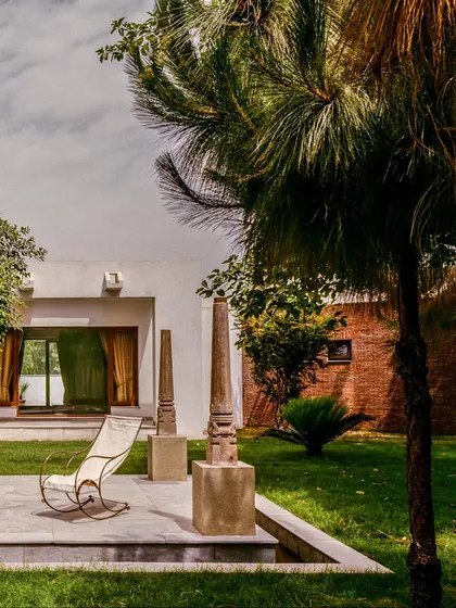The garden at the House of Axes serves as a tranquil oasis. The design addresses the harsh Delhi climate by respecting the environment, grouping living areas around courtyards, and using materials that create a comfortable microclimate.