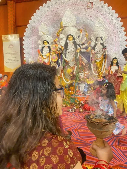 A candid moment of a mother and child watching the pujo rituals together. These are the small, personal stories within the larger festival.