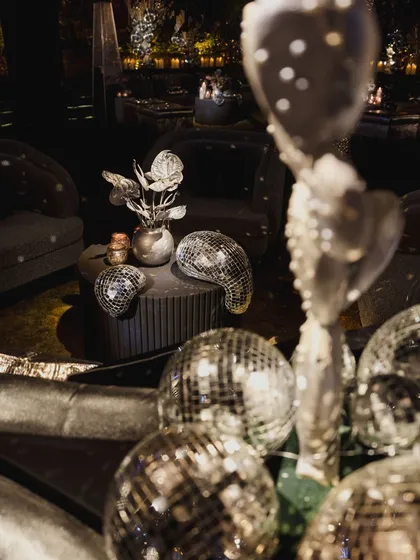 For a disco-themed party, the limit for disco balls does not exist. We scattered them throughout the venue, from centerpieces to floor decor, to ensure every surface reflected the party energy.