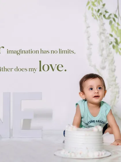 A quiet moment during a first birthday cake smash session. This minimalist studio setup with soft green accents puts all the focus on the little one's curious expression.