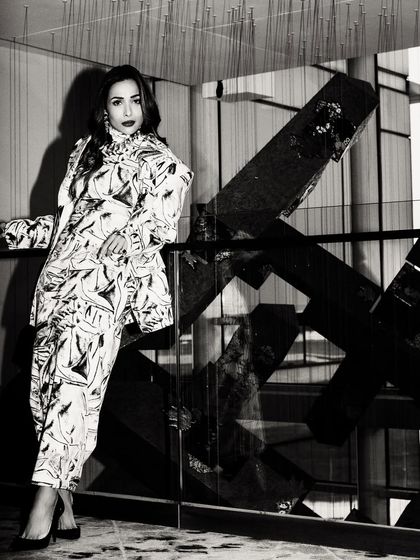 A full-length black and white shot of Malaika Arora. The geometric background and strong shadows create a high-fashion, graphic feel.