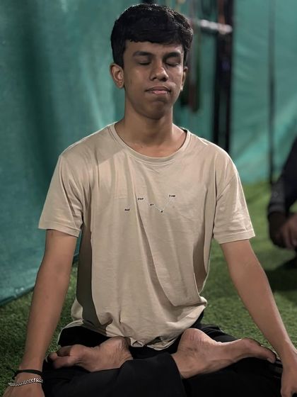 An athlete sits in the lotus pose, a classic posture for meditation that promotes stability and calm.