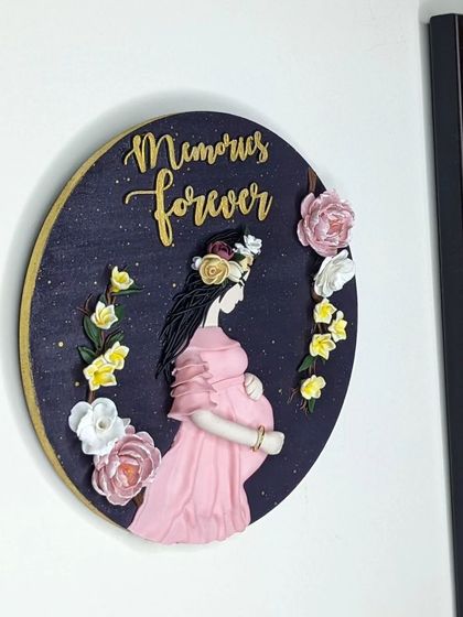 A perfect way to imprint memories forever. This personalized clay wall art, featuring a pregnant mother, looks beautiful hanging on the wall as part of a gallery of family photos.