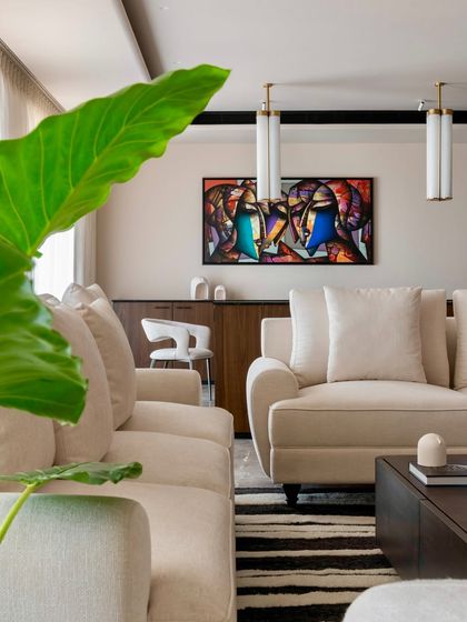 A glimpse of the living room from behind a plant, emphasizing our philosophy of integrating natural elements into our interior spaces.